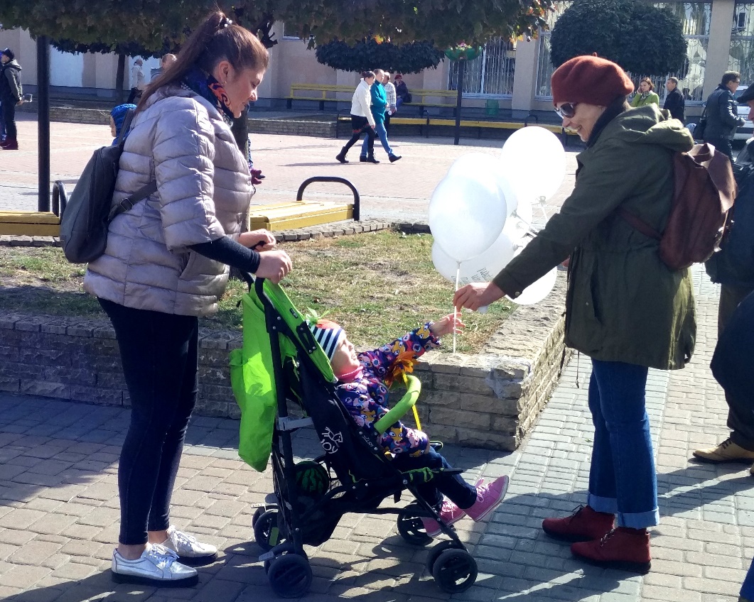 Дитина бере кульку від активістки
