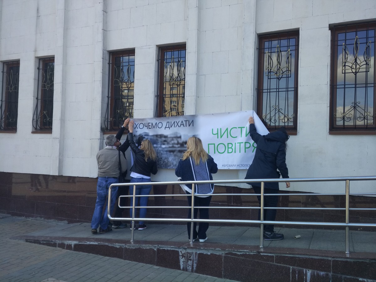 Активісти вішають банер на стіну корпусу Броварської міської ради
